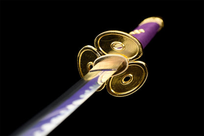 Primo piano della tsuba dorata della Katana Enma e manico avvolto in ito nero